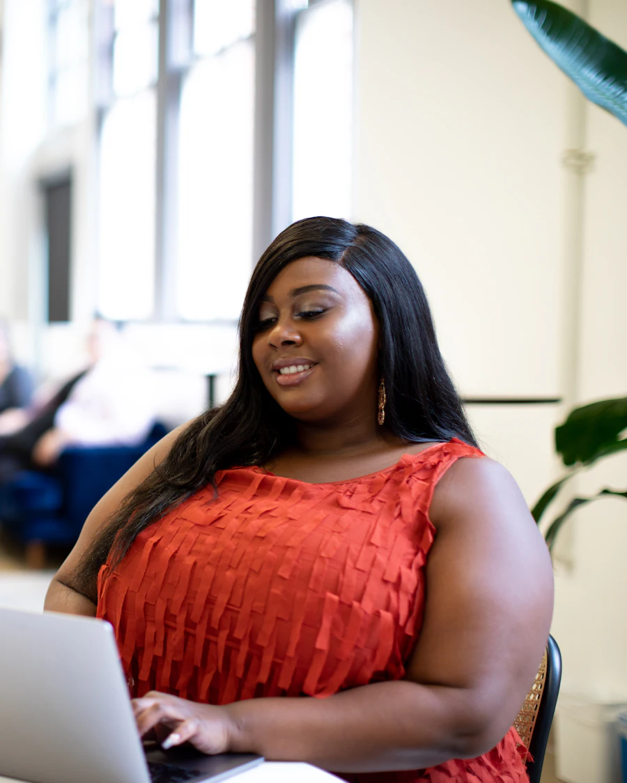A woman working at a laptop in a bright open-plan office.